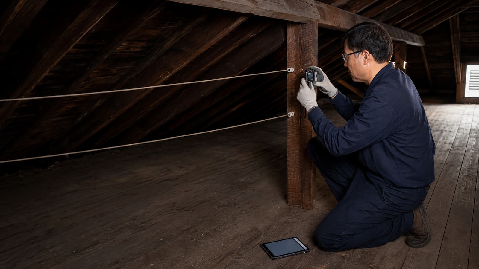 Electrician documenting accessible knob-and-tube wiring for an insurance report